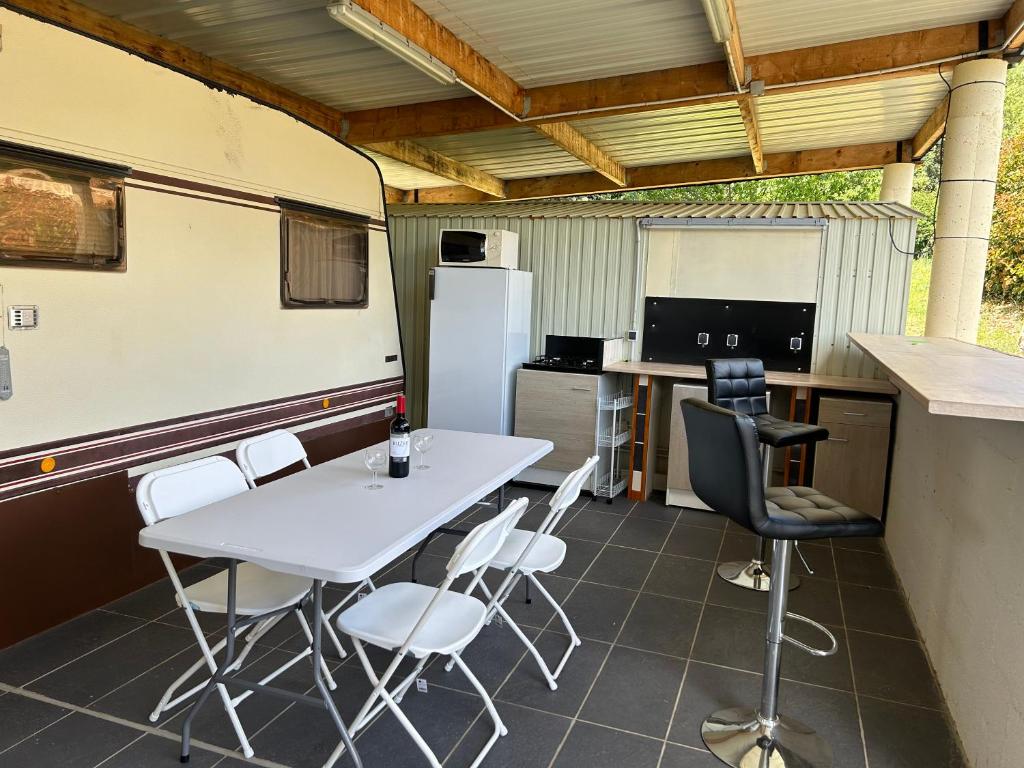 a kitchen with a table and chairs in a trailer at Au chant des cigales in Mons
