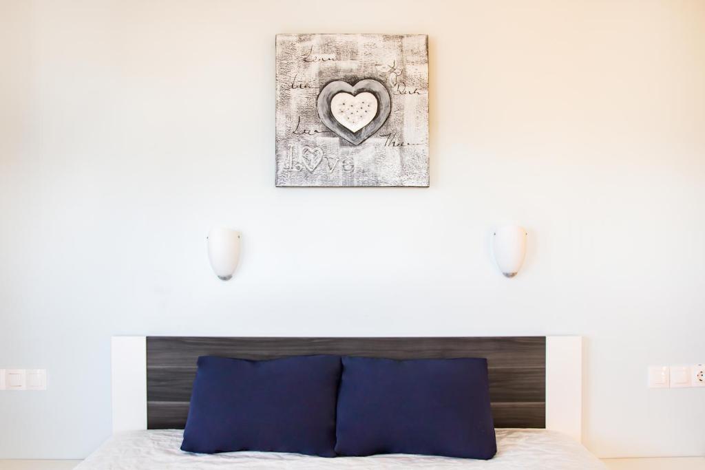 ein Schlafzimmer mit einem Bett mit einem Herz an der Wand in der Unterkunft Sun and Sea in Karpathos