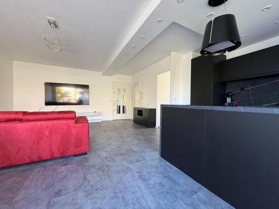 馬賽的住宿－Appartement T3 72 m²，一间带红色沙发的客厅和一间厨房