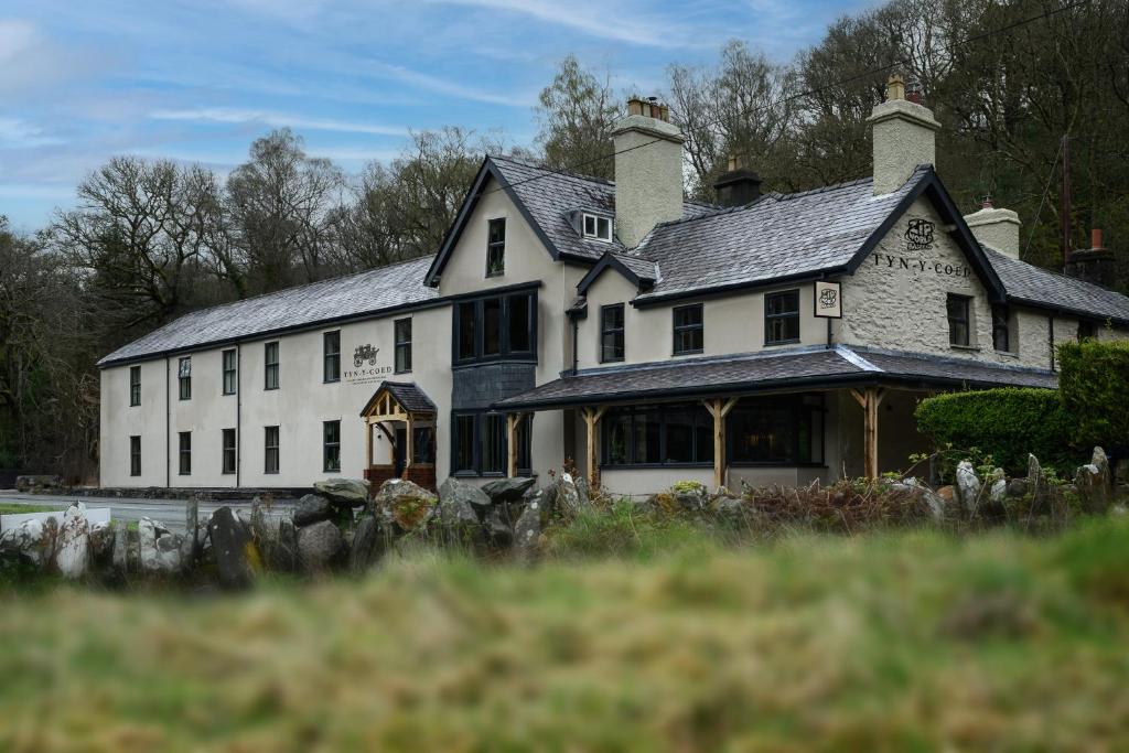 a large white house with a roof at Tyn-y-Coed Inn in Betws-y-coed