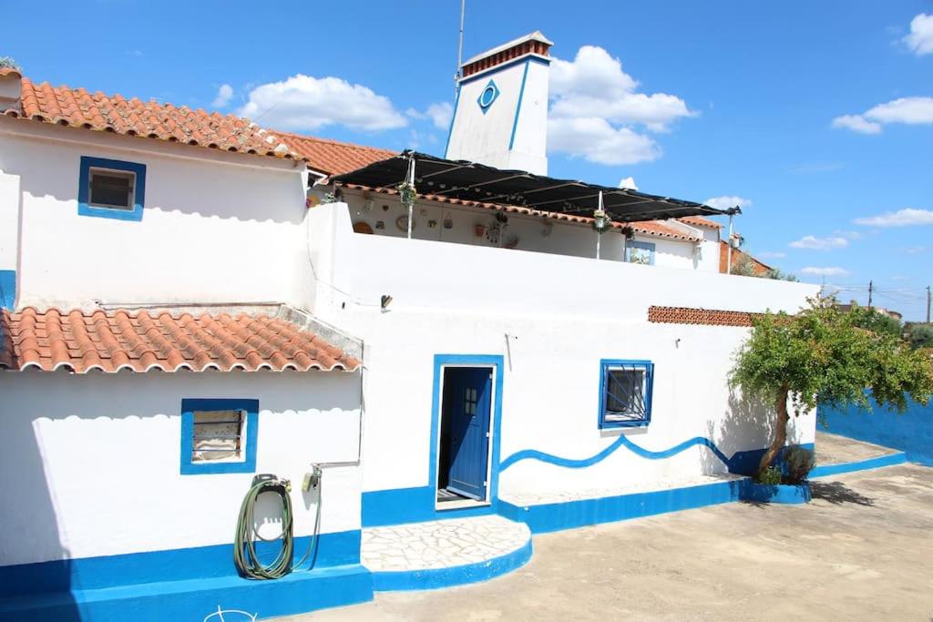un edificio blanco y azul con una torre de reloj en Rosa Mar en Cabeça de Carneiro