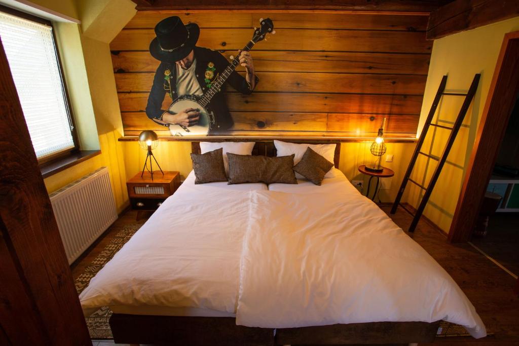- une chambre avec un lit et une guitare sur le mur dans l'établissement VILLA CANTARE, à Obernburg am Main