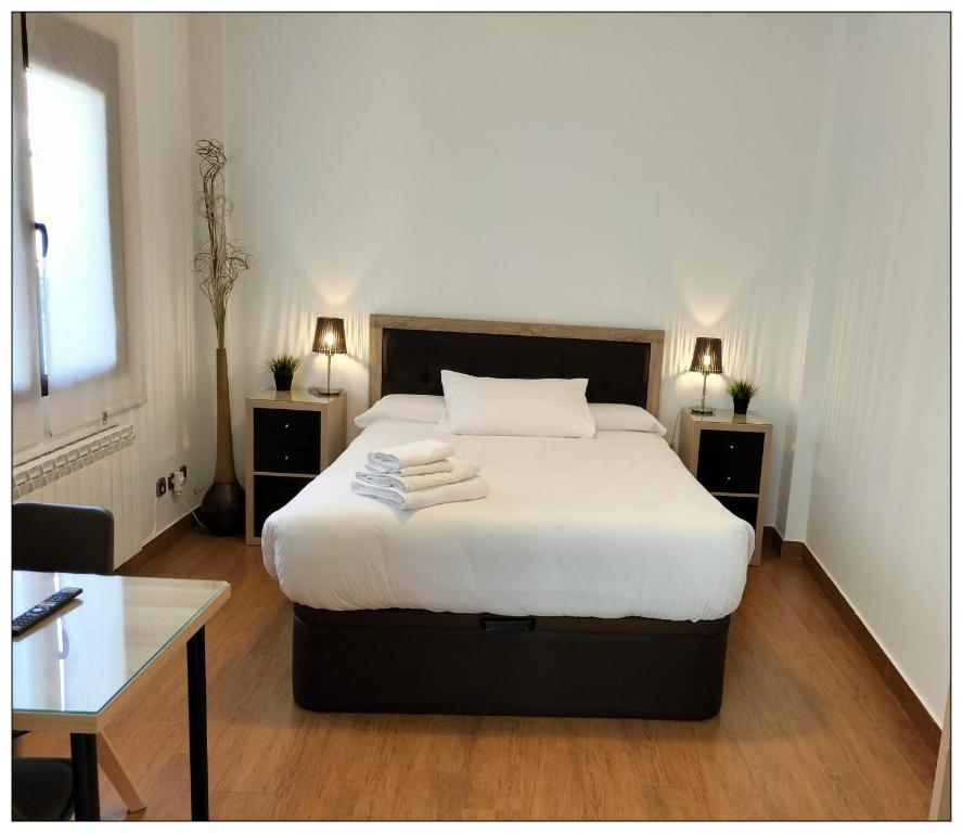 1 dormitorio con 1 cama con 2 mesitas de noche y mesa en Magnífico Alojamiento en el centro en Valdepeñas