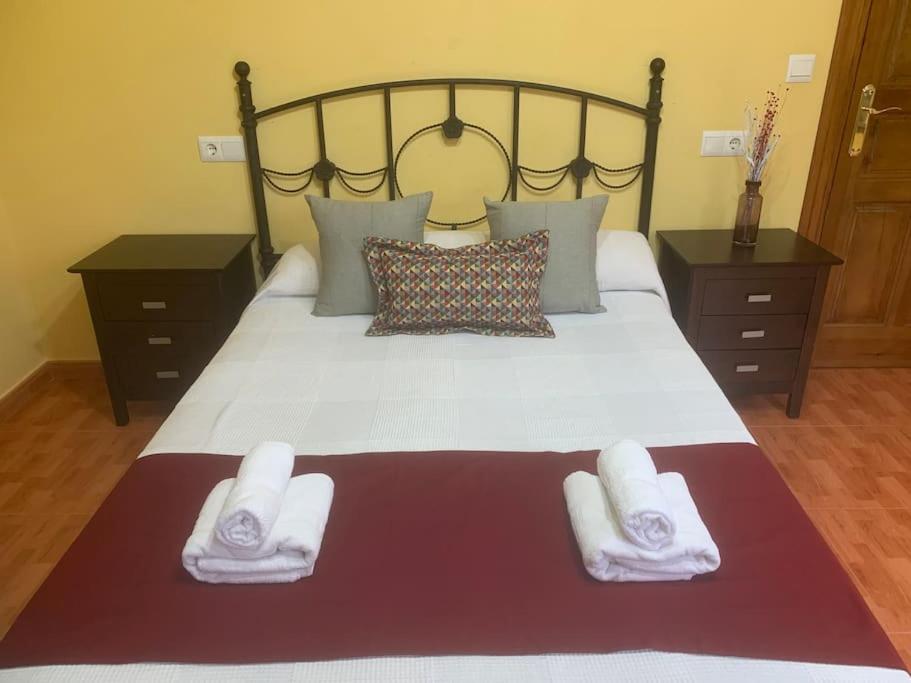 a bedroom with a large bed with towels on it at Apartamentos La Mina de Viñón. in Santa Eulalia