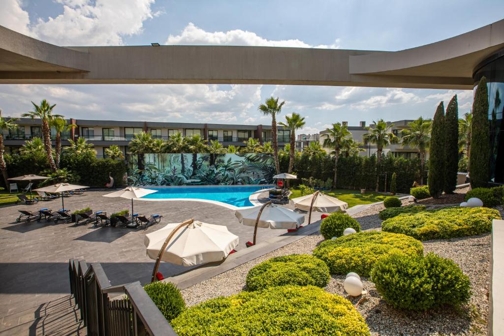 a courtyard with a swimming pool and a resort at DoubleTree By Hilton Izmir Airport in Izmir
