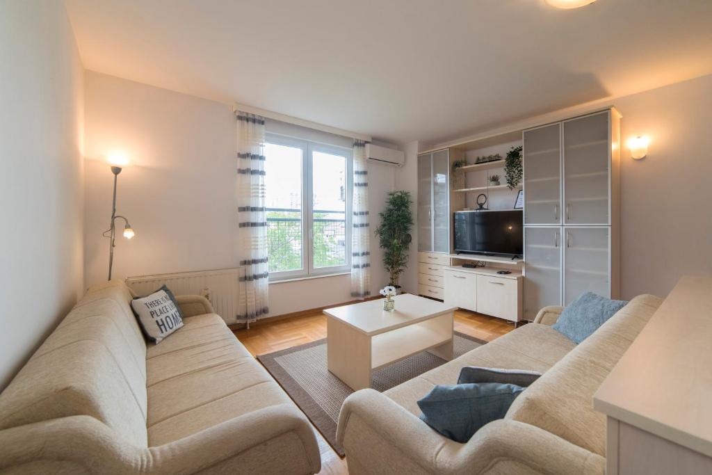 a living room with a couch and a tv at Apartment Marci with parking in Zagreb