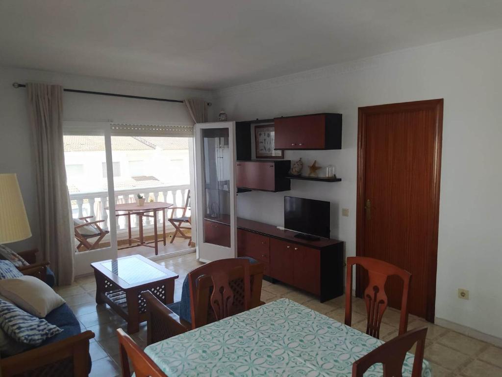 a living room with a table and a dining room at Amplio apartamento Blanes in Blanes