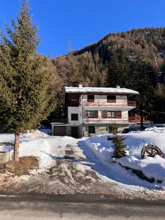 a building in the snow in front of a mountain at Appartamento in villa a Champoluc Ayas in Brusson