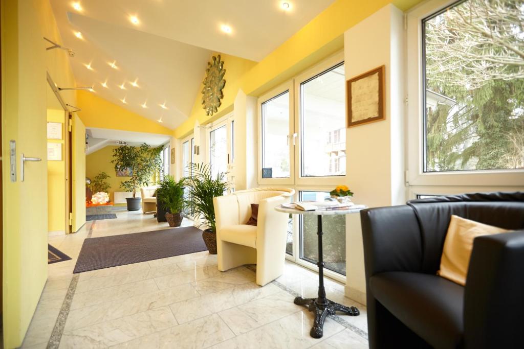 a hallway with couches and a table and windows at Hotel Sonne in Bad Homburg vor der Höhe