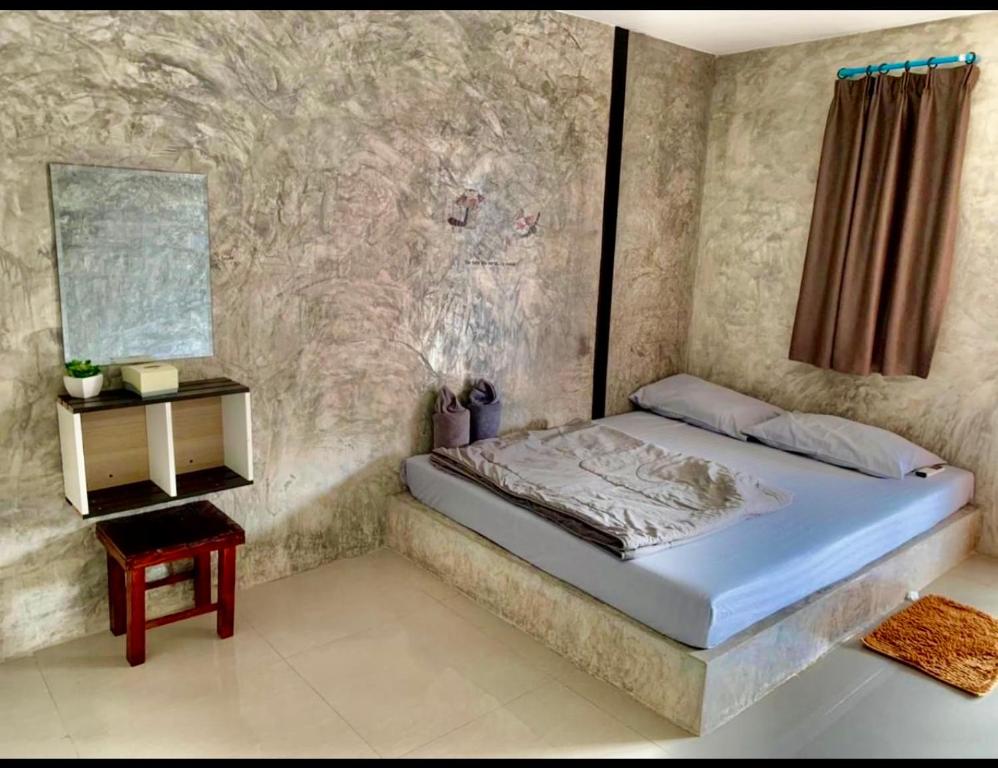 a bedroom with a bed and a side table at Cactus Resort in Ko Larn