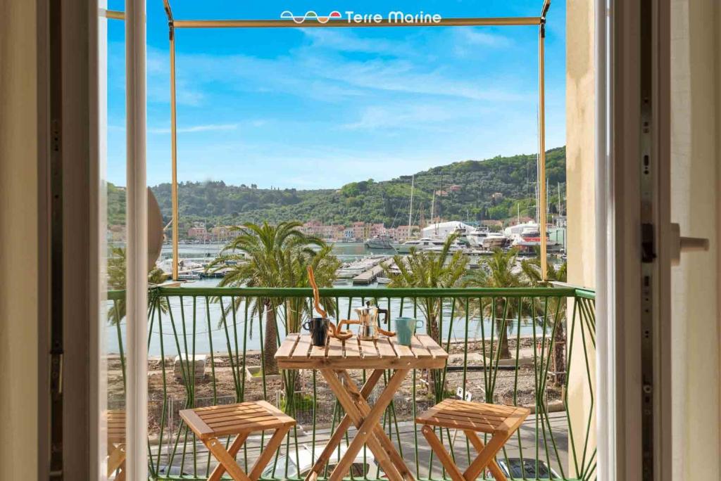 uma varanda com mesa e cadeiras e vista para a água em Giuly House, Terre Marine em Le Grazie