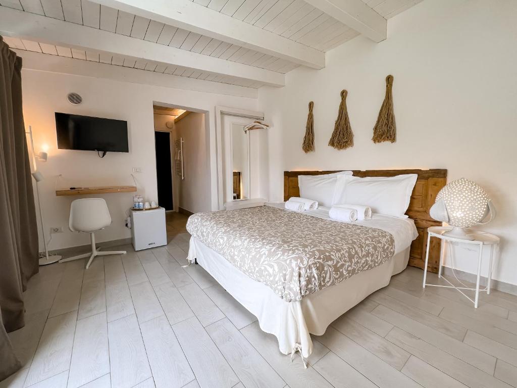 a bedroom with a large bed and a television at San Michele Luxury Rooms in Matera
