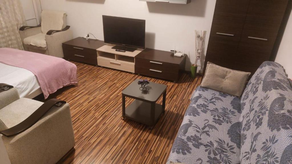 a living room with a bed and a tv at happy home in Bucharest
