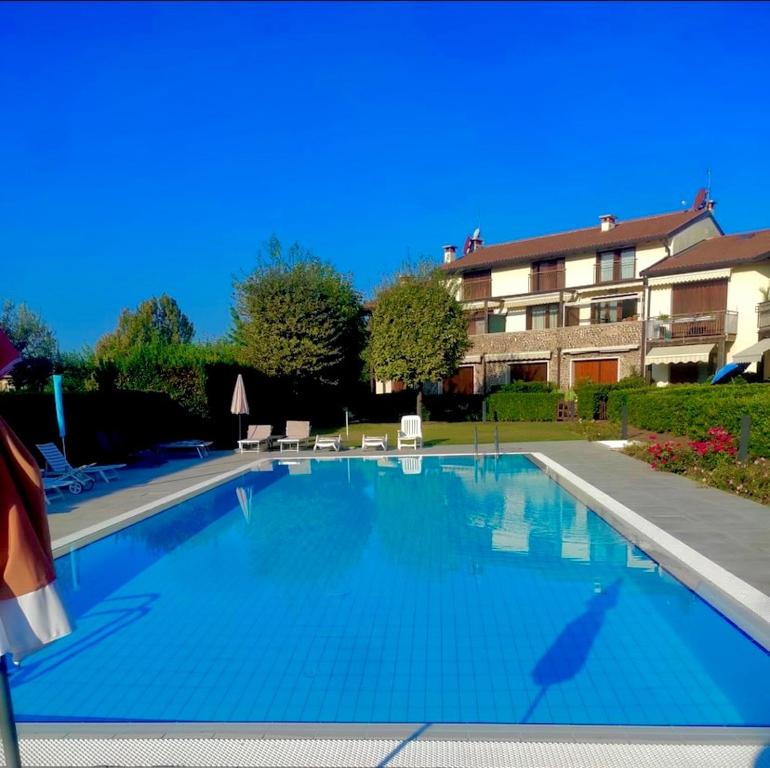 uma grande piscina azul em frente a um edifício em Appartamento Elena em Garda