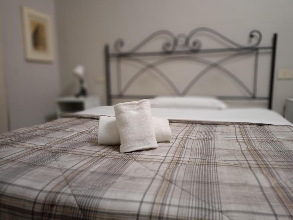 a bed with two towels sitting on top of it at 6 Keys in Pisa