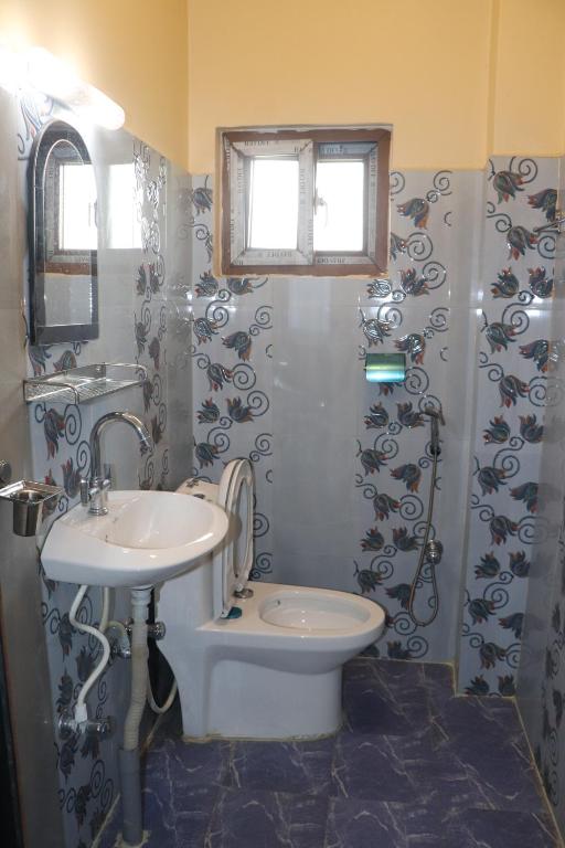 e bagno con lavandino, servizi igienici e doccia. di Hotel Flycatcher Chitwan- A jungle Safari Home a Sauraha