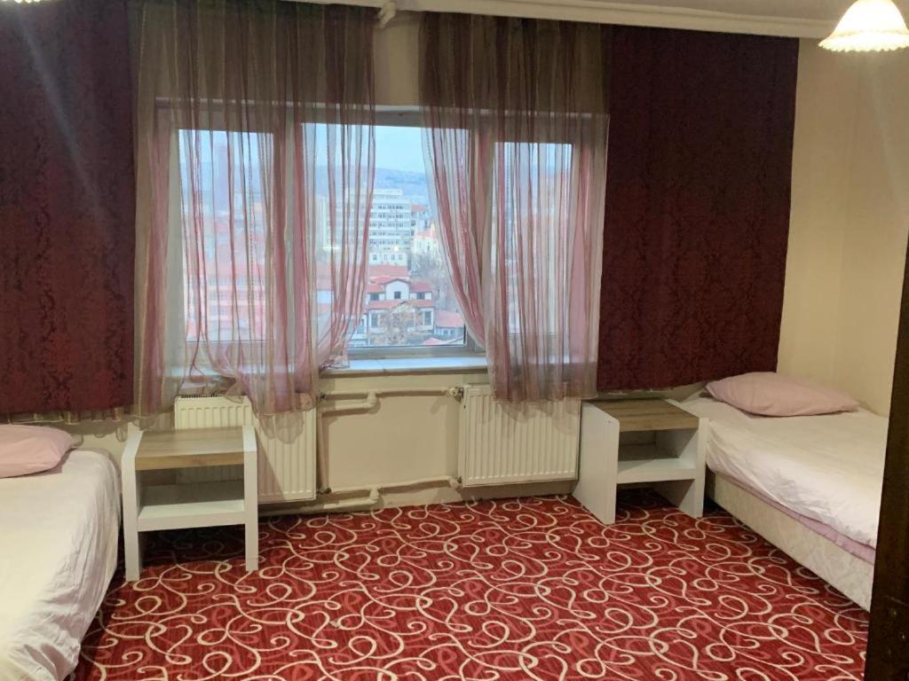 a hotel room with two beds and a window at Altunlar in Altındağ