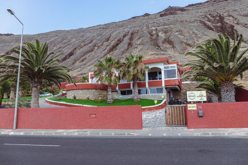 a house with palm trees in front of a mountain at Porto Santo Destination in Porto Santo