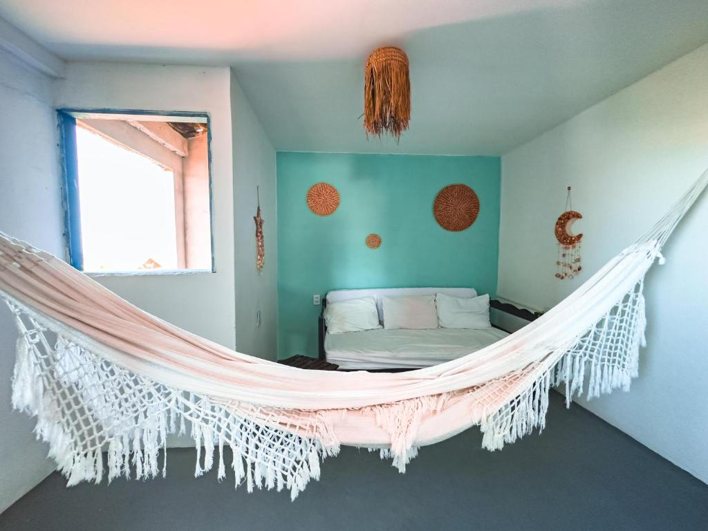 a hammock in a room with a bed at Beco do Preá - Kite Apartamentos e Suítes Beira Mar in Prea