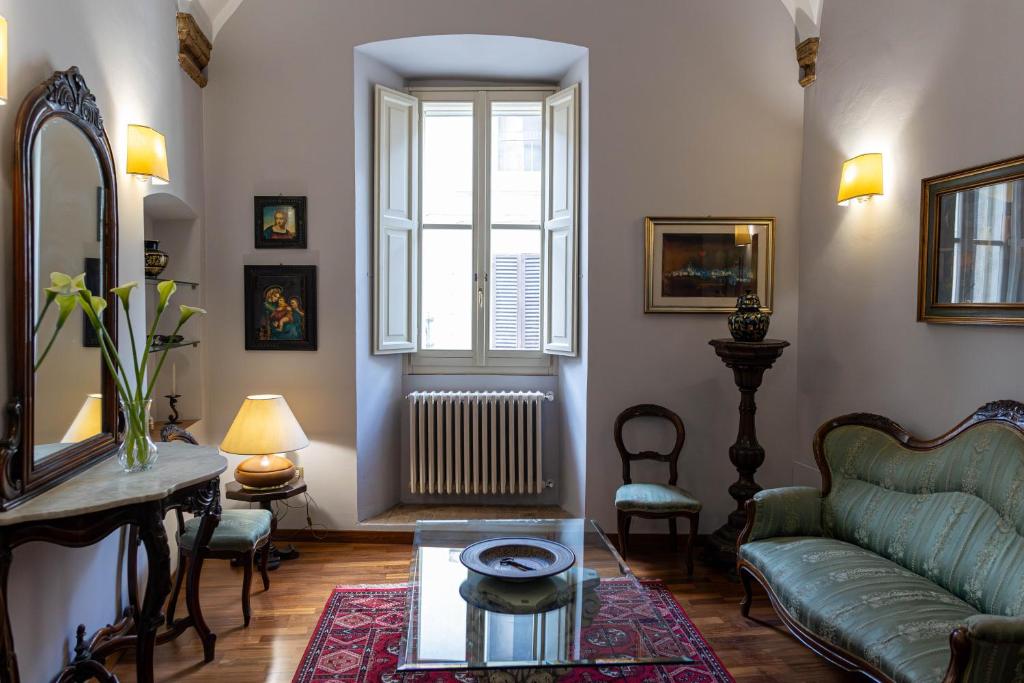 sala de estar con sofá y ventana en Palazzo Crescimbeni en Bevagna