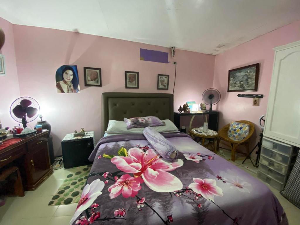 - une chambre avec un lit fleuri dans l'établissement Crystal Aire village, à General Trias