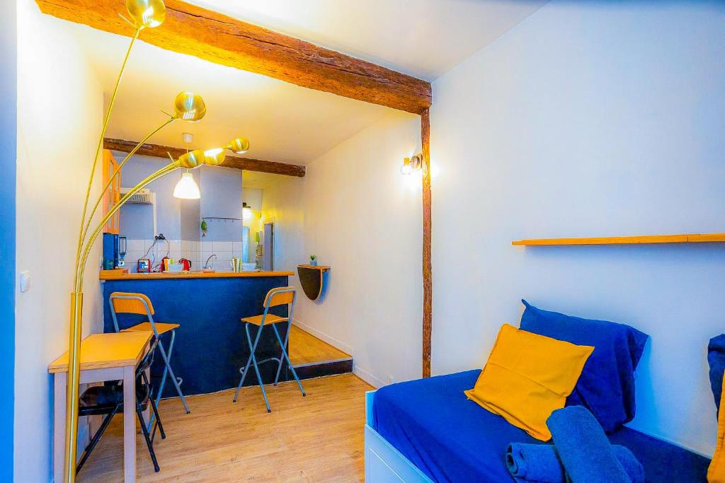 een slaapkamer met een blauw bed en een keuken bij Cosy Beautiful Studio Heart of Paris Saint-Germain des Prés in Parijs