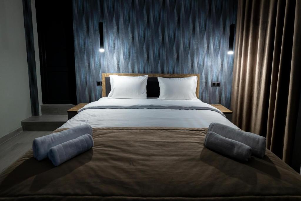 a bedroom with a large bed with two pillows at EVN Rooms in Yerevan