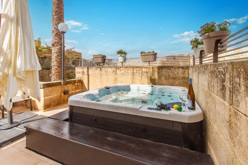 eine Whirlpool-Badewanne auf einer Terrasse in der Unterkunft Harbour Views Gozitan Villa Shared Pool - Happy Rentals in Mġarr