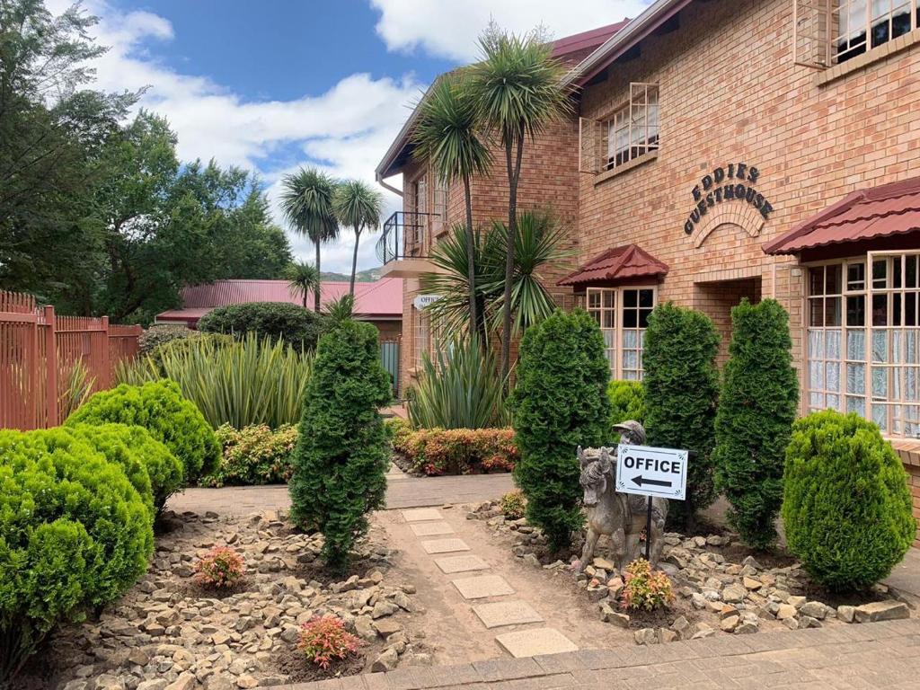 a house with a sign in front of a yard at Clarens Eddies Guest house in Clarens