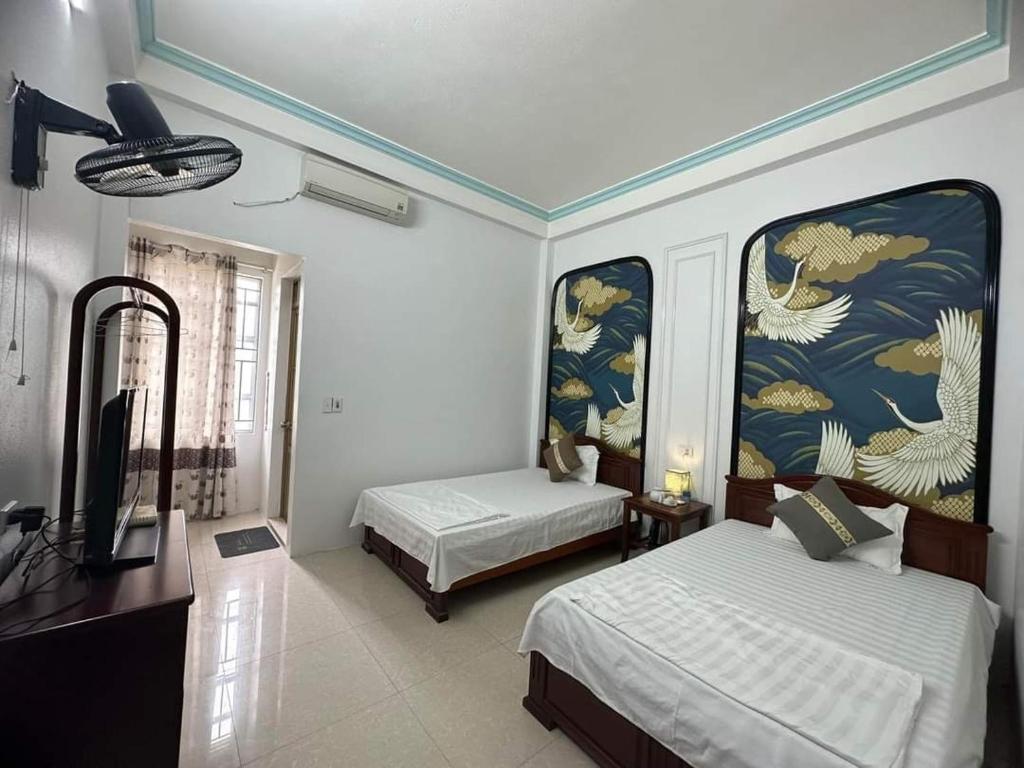 1 dormitorio con 2 camas y TV de pantalla plana en Khách sạn Thùy Dương 2 en Bảo Lạc