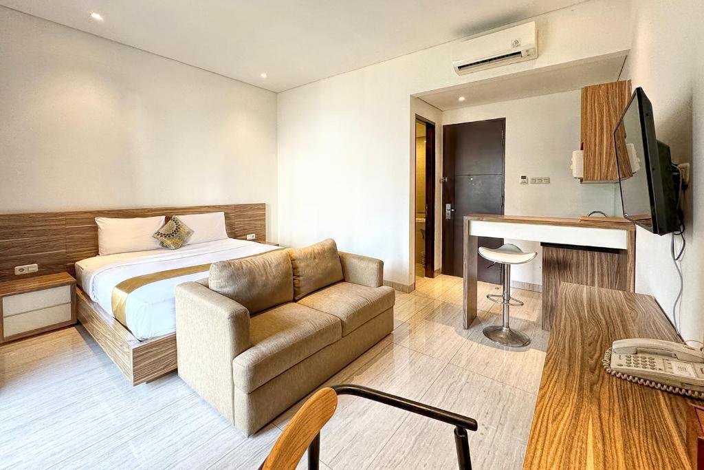 a hotel room with a bed and a couch at Rasuna Icon Hotel in Jakarta