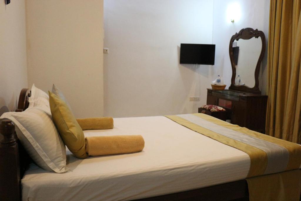 a bedroom with a bed with a chair and a television at Xotic Resort Upper Floor in Kurunegala