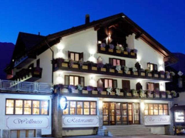 a large white building with lights in front of it at Hotel Presena in Passo del Tonale