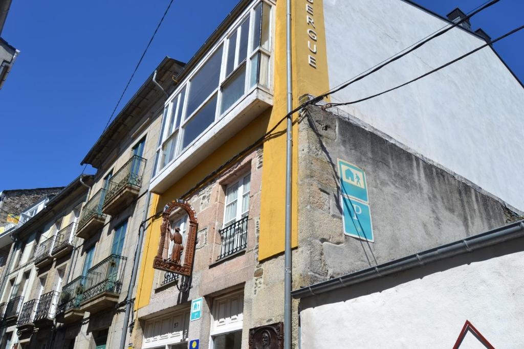 een gebouw met een bord aan de zijkant bij Albergue Internacional in Sarria