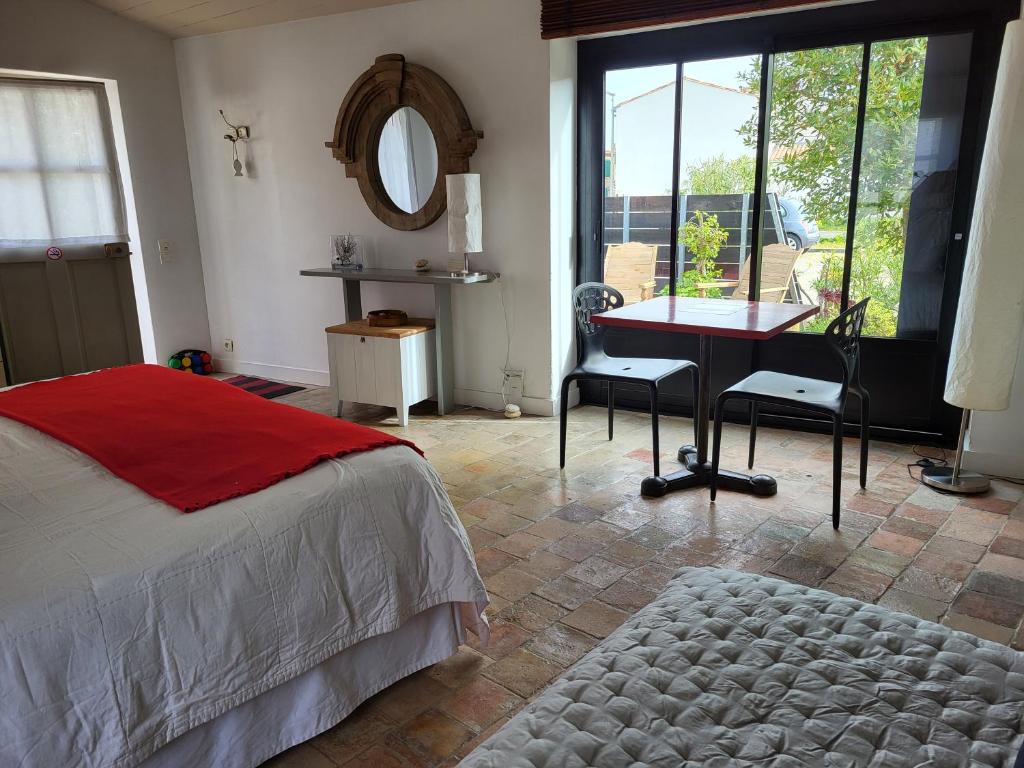 a bedroom with a bed and a desk and a mirror at Ma Chambre d'Amis in Saint-Clément-des-Baleines