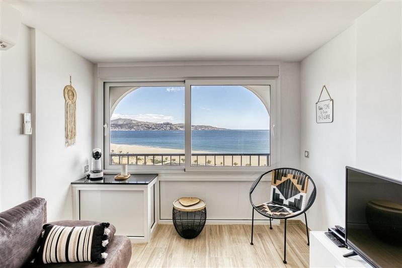una sala de estar con una gran ventana con vistas al océano en Sea-CHIC Appartement, en Empuriabrava