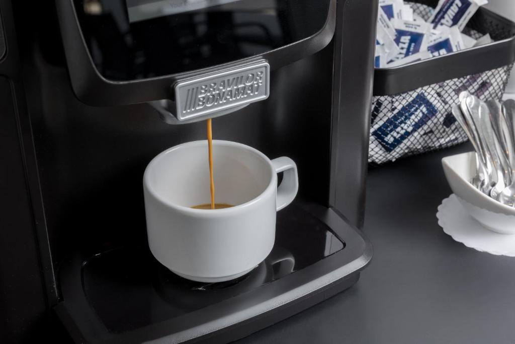 a cup of coffee with a sign in a coffee machine at Maj Luxury Residence in Poreč