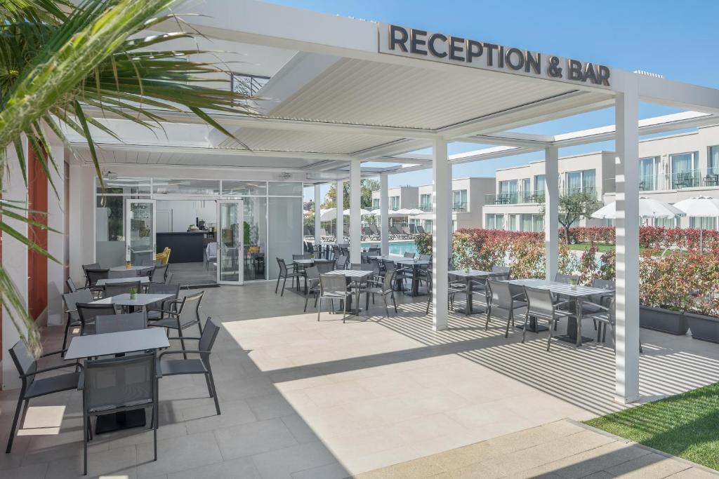 an outdoor patio with tables and chairs and a restaurant at Maj Luxury Residence in Poreč