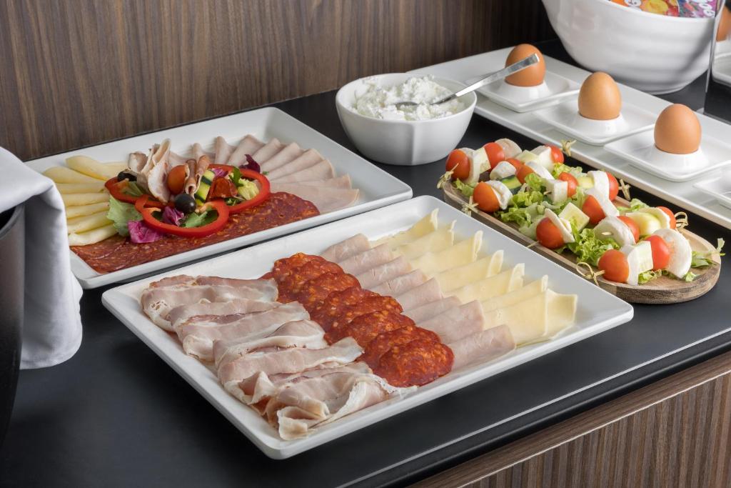a buffet with three trays of food on a table at Maj Luxury Residence in Poreč