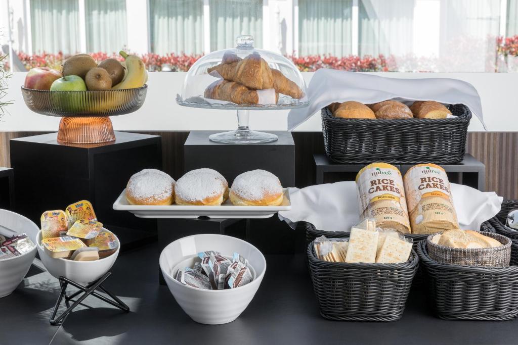 a table with baskets of bread and pastries on it at Maj Luxury Residence in Poreč