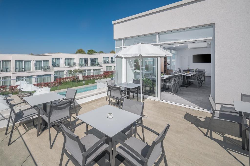 a patio with tables and chairs and a building at Maj Luxury Residence in Poreč