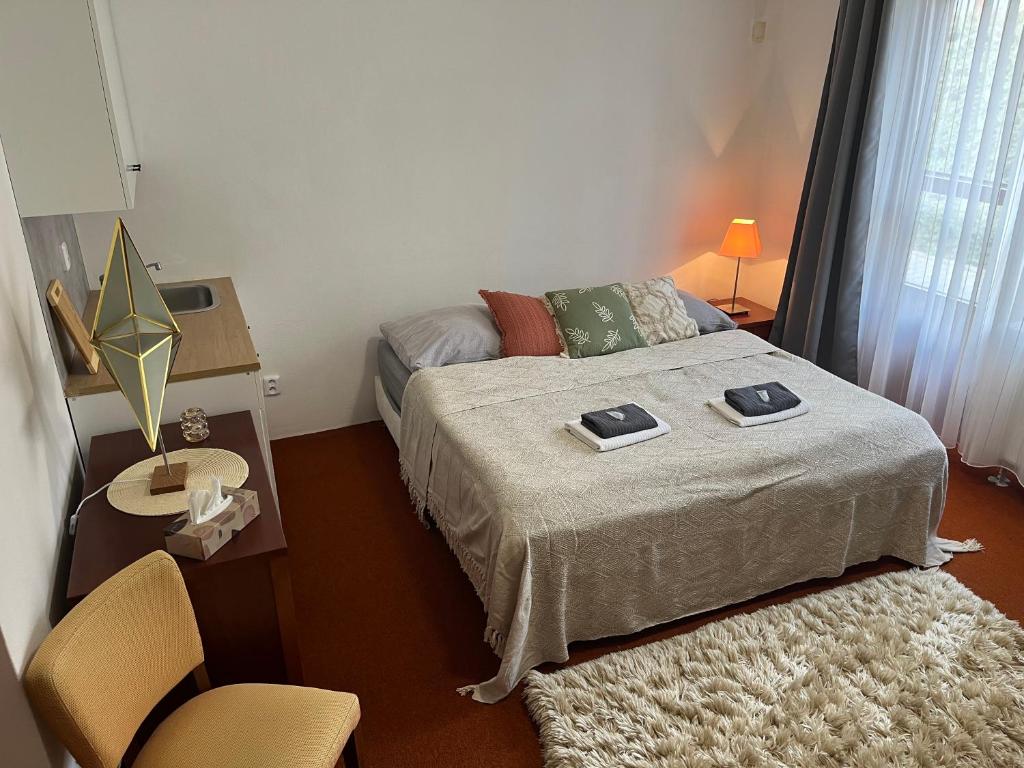 a small bedroom with a bed and a chair at Simply rooms in Slavkov u Brna