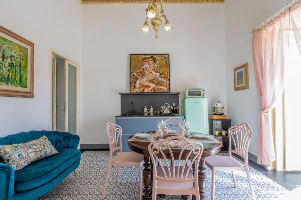 salon ze stołem i krzesłami oraz niebieską kanapą w obiekcie Palazzo d'Autore - Luxury Home - Ragusa Centro w mieście Ragusa