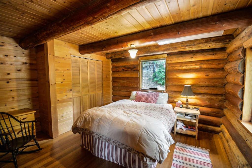 a bedroom with a bed in a log cabin at cns group in Gampaha