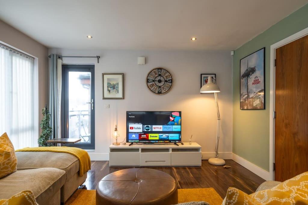 Il comprend un salon doté d'un canapé et d'une télévision à écran plat. dans l'établissement Stylish Unique 2 Bedroom Duplex With a Balcony & Free City Parking, à Belfast