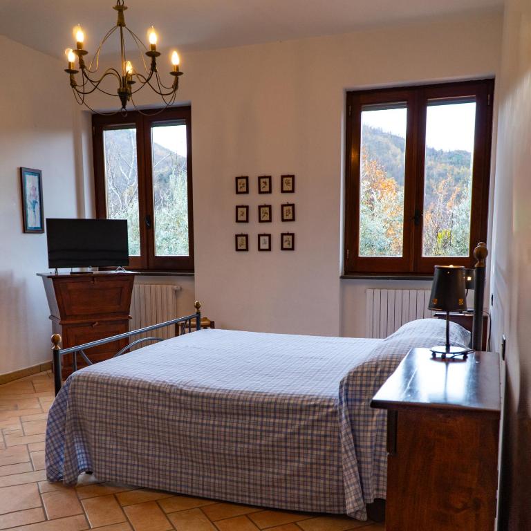 1 dormitorio con 1 cama y 2 ventanas en Agriturismo Casale Piè d'Eco, en Calvanico