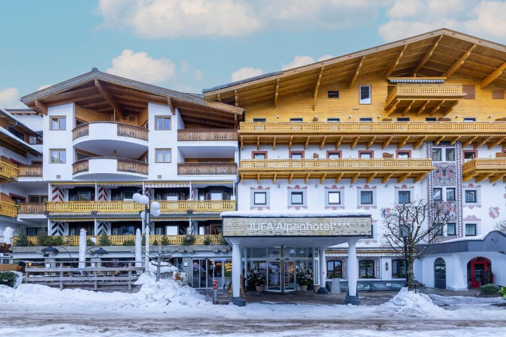 un hôtel dans la neige devant un bâtiment dans l'établissement JUFA Alpenhotel Saalbach, à Saalbach-Hinterglemm