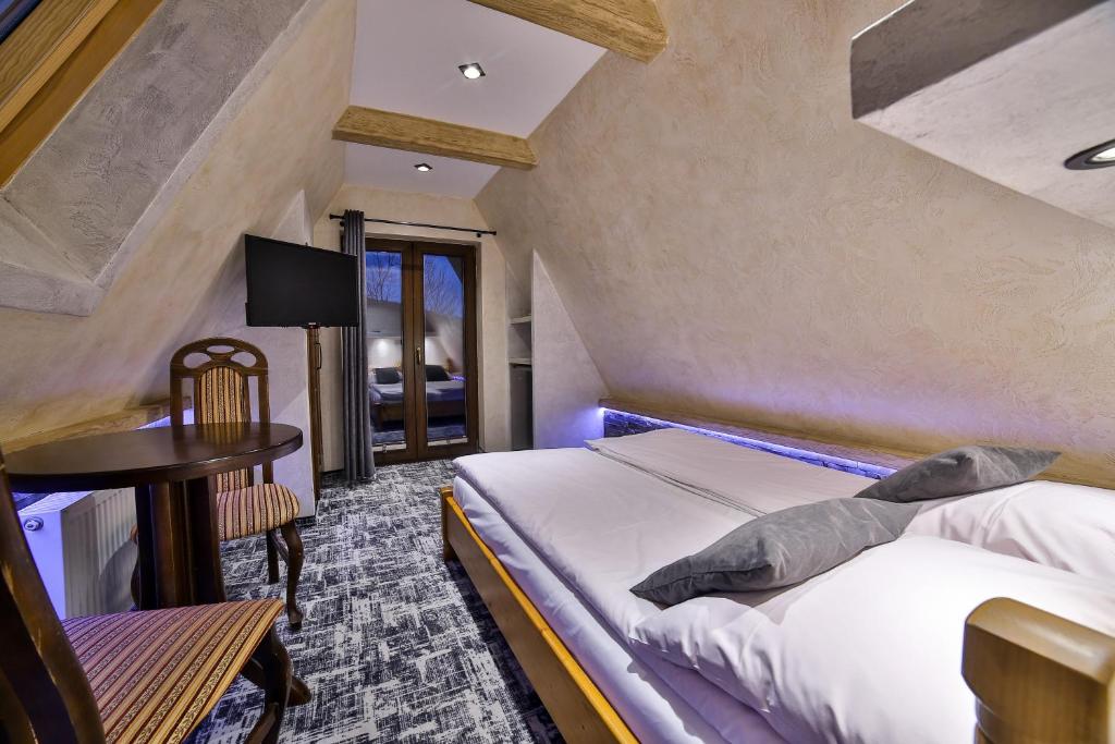 1 dormitorio con 1 cama y 1 mesa en una habitación en Szarotka Wynajem Pokoi, en Zakopane