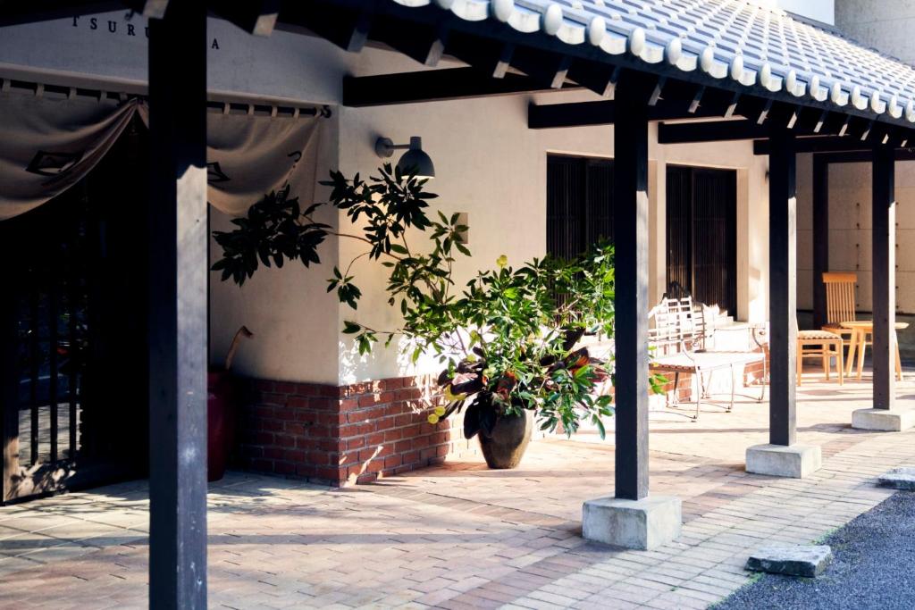 une maison avec une plante en pot devant elle dans l'établissement 湯の鶴迎賓館鶴の屋Tsurunoya, à Yunotsuru