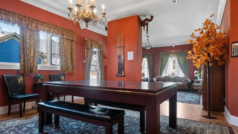 a piano in a living room with red walls at Governor's Mansion beautiful 3bd with pool table in Leadville